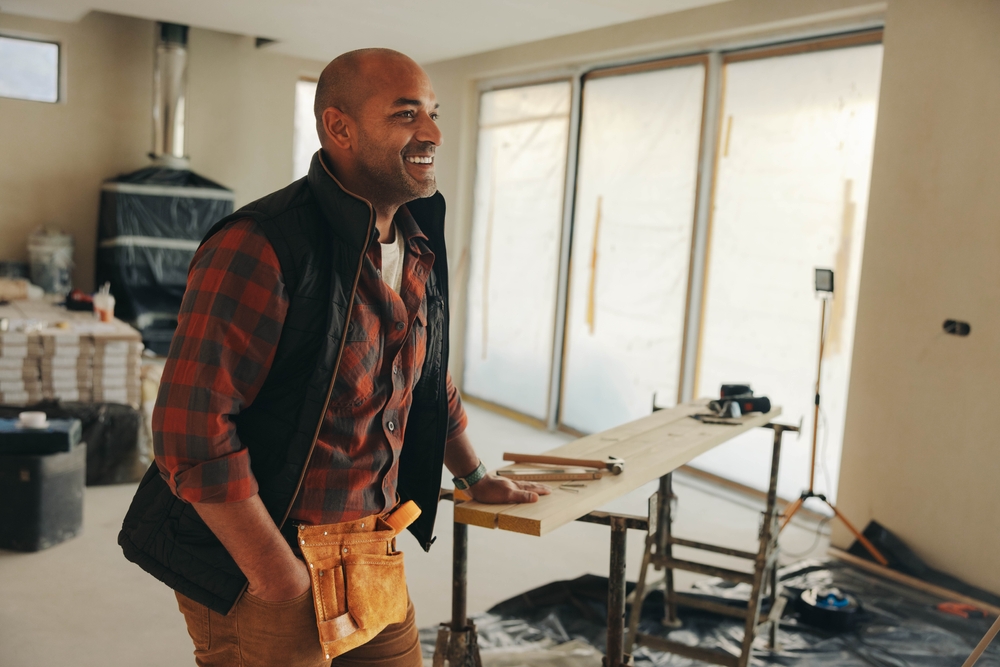 | construction spike Mature man happily renovates his own home, working in the kitchen with a smile. This DIY enthusiast embodies the spirit of a skilled worker, undertaking a home improvement project with determination.