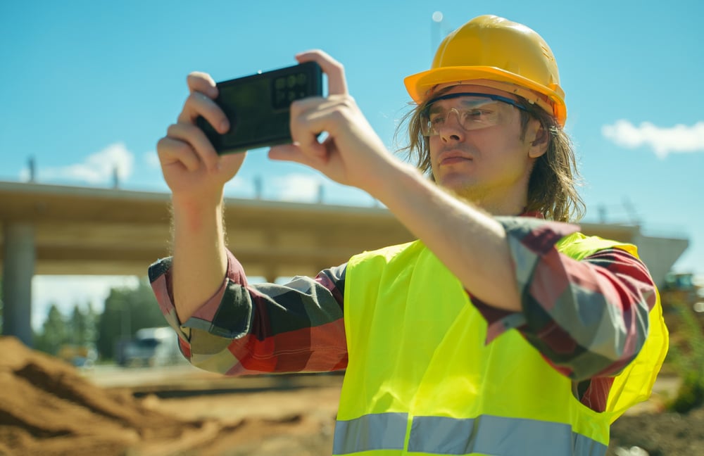 Buildingcontractorwithmobilephoneshootingworktheydone | construction spike Buildingcontractorwithmobilephoneshootingworktheydone