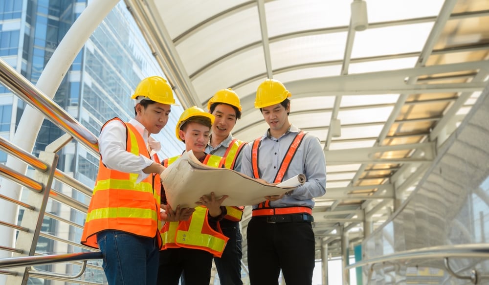 Teamofengineersandarchitectsfourmalewearingsafetyyellow | construction spike Teamofengineersandarchitectsfourmalewearingsafetyyellow
